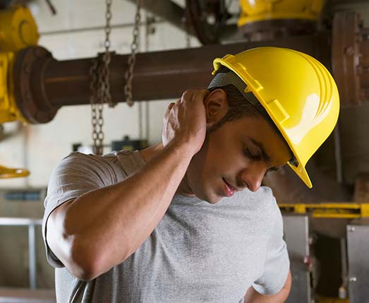 man in hard hat massaging the back of his neck