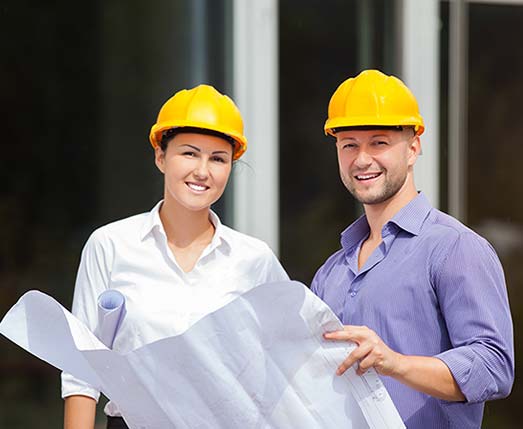 a man and woman wearing hard hats on a job site
